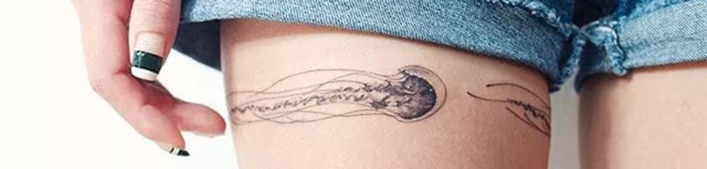 wrap around thigh black ink jellyfish tattoo